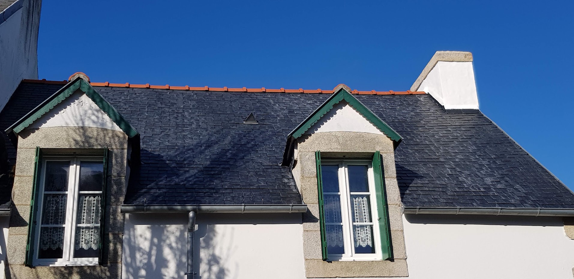 Toit de Penty breton en ardoises et ses petites fen&ecirc;tres aux volets verts